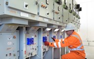 A man doing a checkup on switchgear monitors