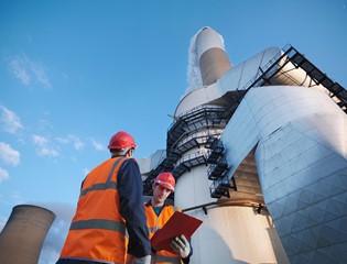 Two men in orange vest in a power plant